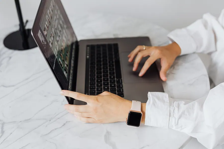 Mains sur un clavier d'ordinateur pendant la saisie d'un suivi de loyers