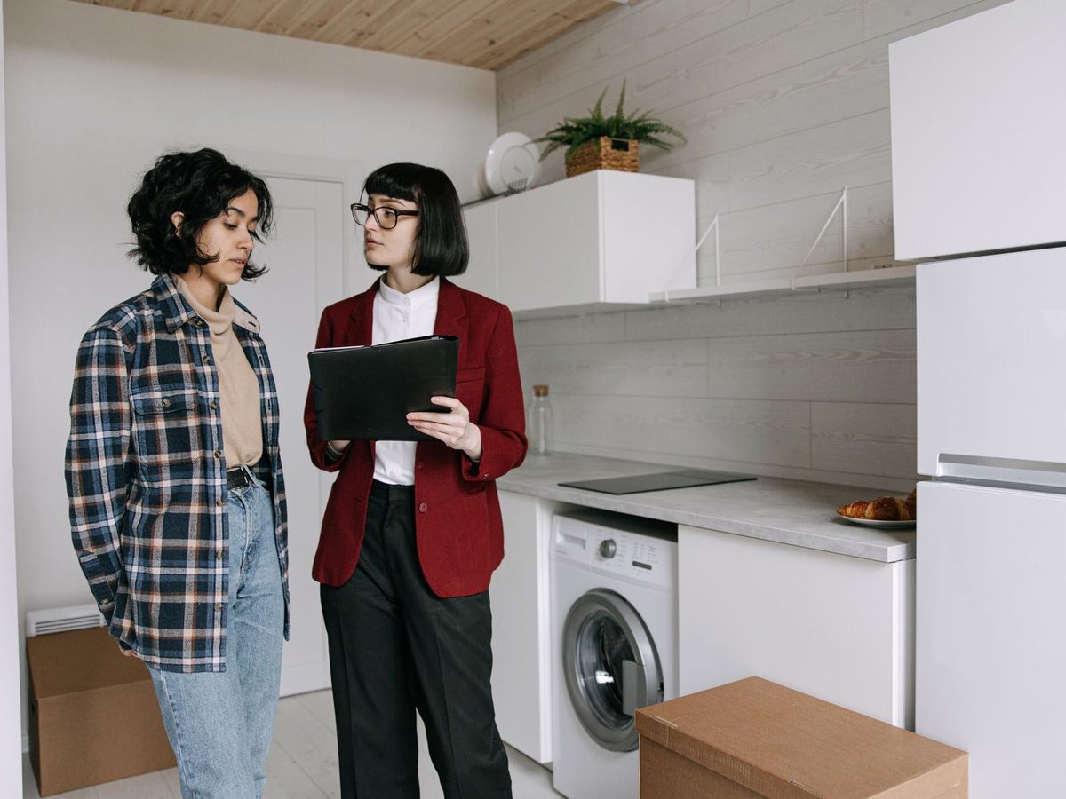 Deux personnes font le tour d'un logement, tablette en main