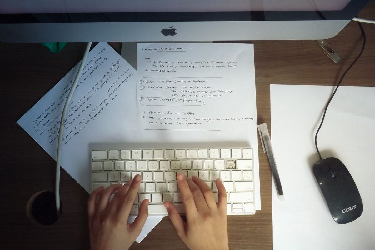 Bureau de la rédaction : écran, carnet de notes et documents annotés